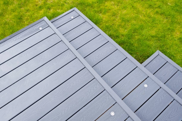 Modern gray composite decking steps leading down to green grass. -constructed decks