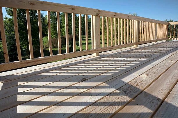 Worker assembling deck boards with tools, level, and measuring equipment. -deck installation