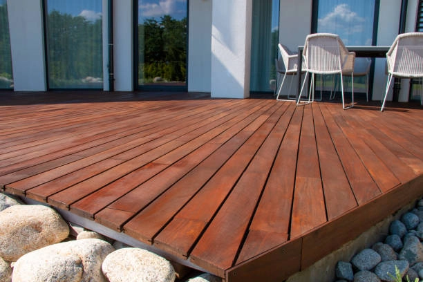 Polished wooden deck with modern outdoor furniture and stone foundation. -decking wood