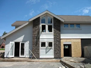 Modern home under renovation with stone facade and siding updates. -general construction services